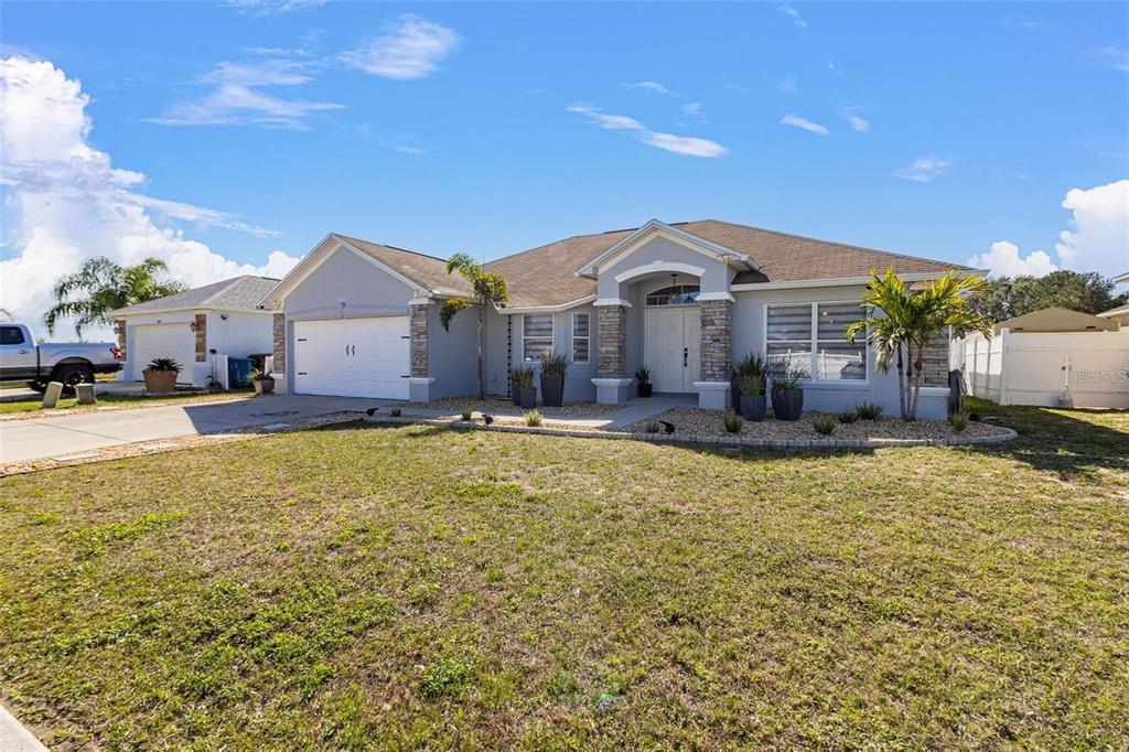 A single-story house with a gray exterior, stone accents, and a two-car garage — 3419 PATTERSON HEIGHTS DRIVE, HAINES CITY, FL