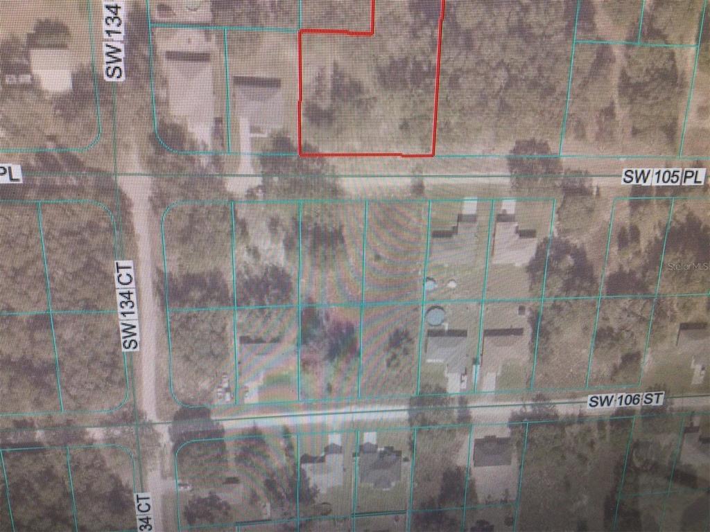 This is an aerial map showing a highlighted parcel of land near residential streets — 0 SW 105 PLACE, DUNNELLON, FL