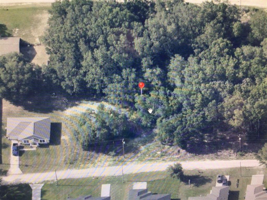 An aerial view shows a wooded, undeveloped lot with a red location pin — 0 SW 105 PLACE, DUNNELLON, FL