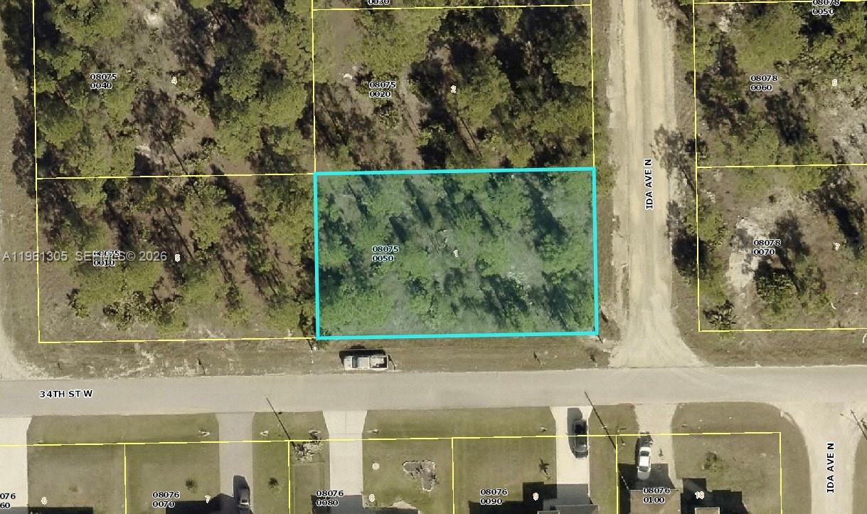 This is an aerial map showing a vacant, wooded residential lot outlined in blue — 3400 Irma Ave N, Lehigh Acres FL 33971, LEHIGH ACRES, FL