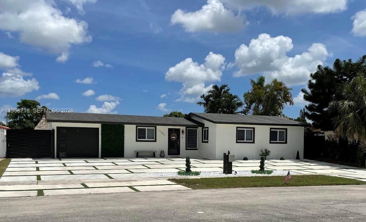 A single-story house with a white exterior, dark trim, and a large paved driveway — 17831 NW 84th Ct, Miami FL 33015, MIAMI, FL