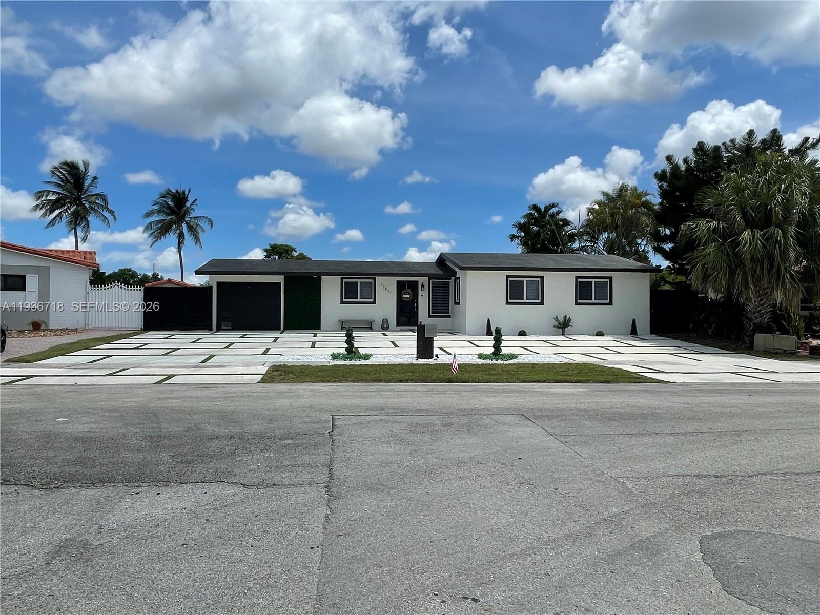 A single-story white house features a large concrete driveway with grass grid accents — 17831 NW 84th Ct, Miami FL 33015, MIAMI, FL