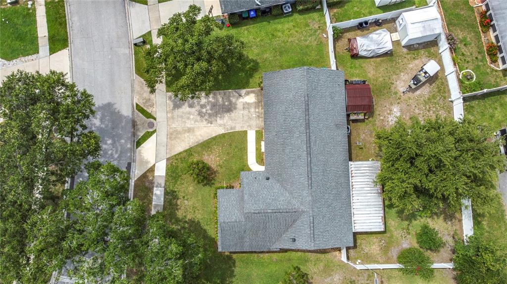 An aerial view shows a single-story house with a gray roof, driveway, and fenced backyard — 4702 HOPESPRING DRIVE, ORLANDO, FL