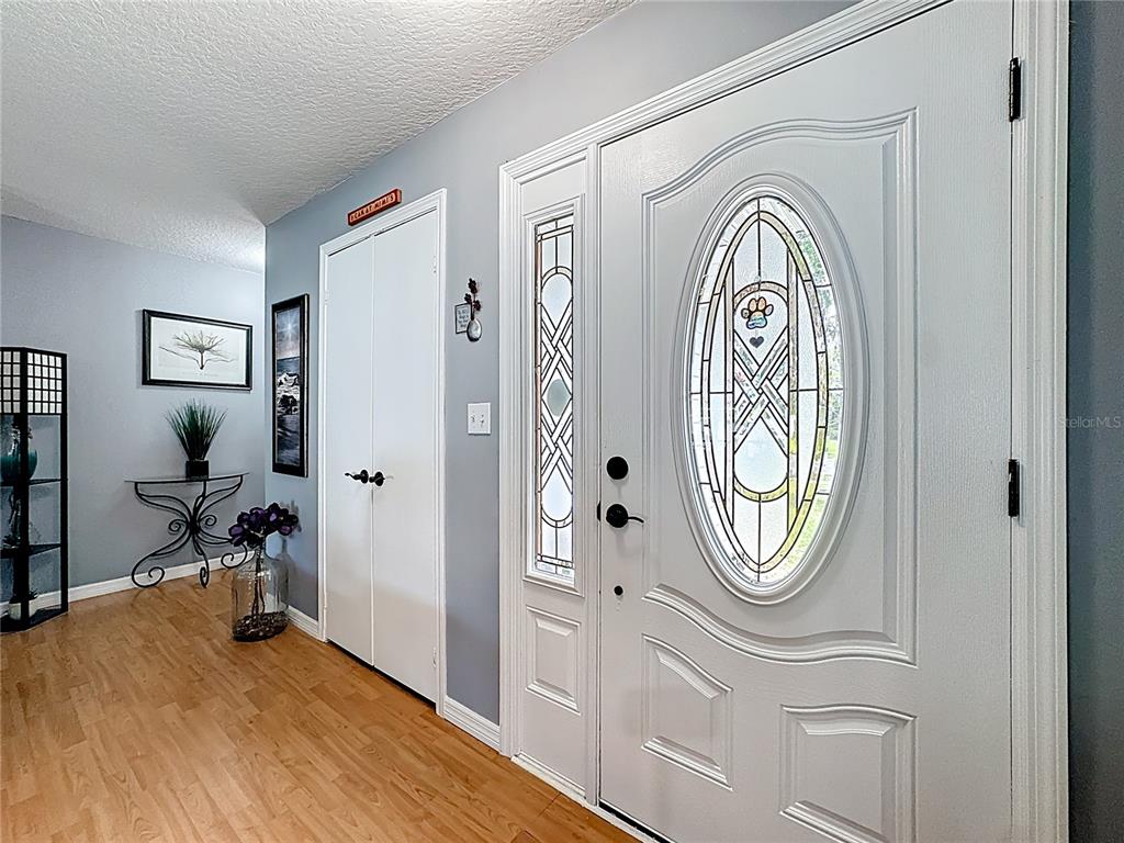An entryway features light wood flooring, gray walls, a white door with glass, and a closet — 4702 HOPESPRING DRIVE, ORLANDO, FL