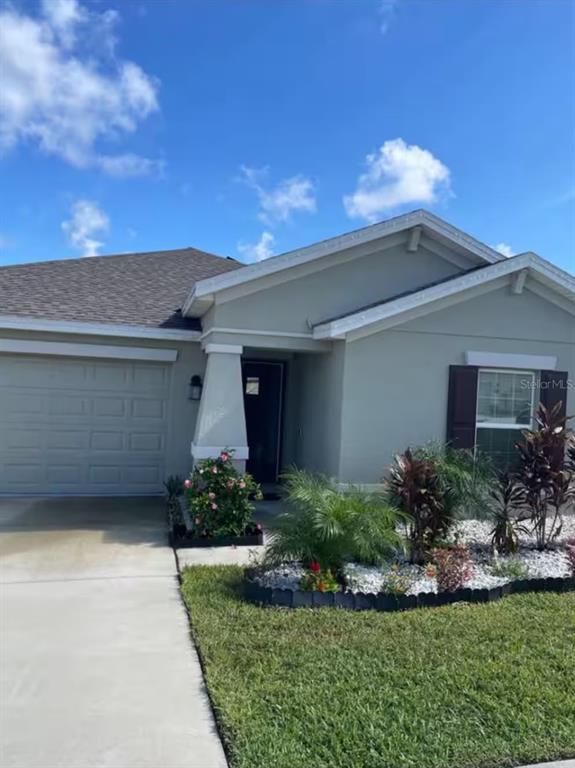 A single-story house with a gray exterior, a one-car garage, and a landscaped front yard — 815 OFANTO WAY, HAINES CITY, FL