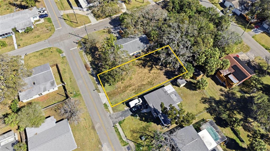 An aerial view shows a vacant, rectangular residential lot outlined in yellow between existing houses — 7214 OELSNER STREET, NEW PORT RICHEY, FL