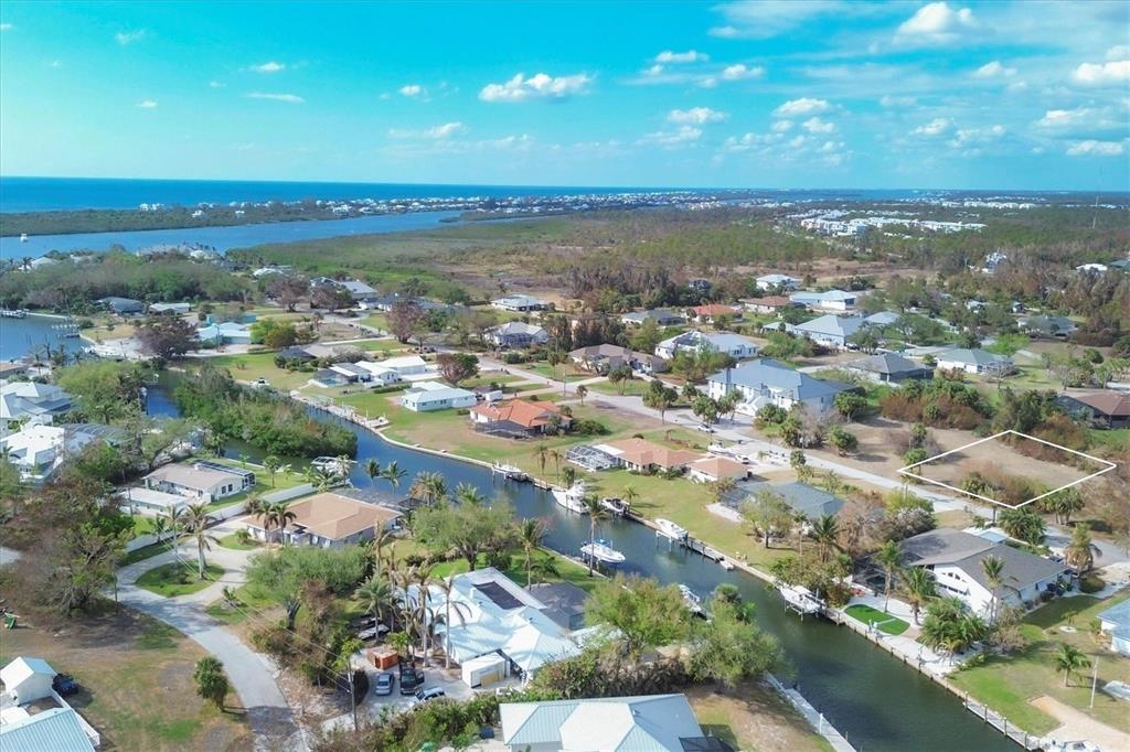 An aerial view shows a vacant residential lot outlined in white within a waterfront neighborhood — 170 SPYGLASS ALLEY, PLACIDA, FL