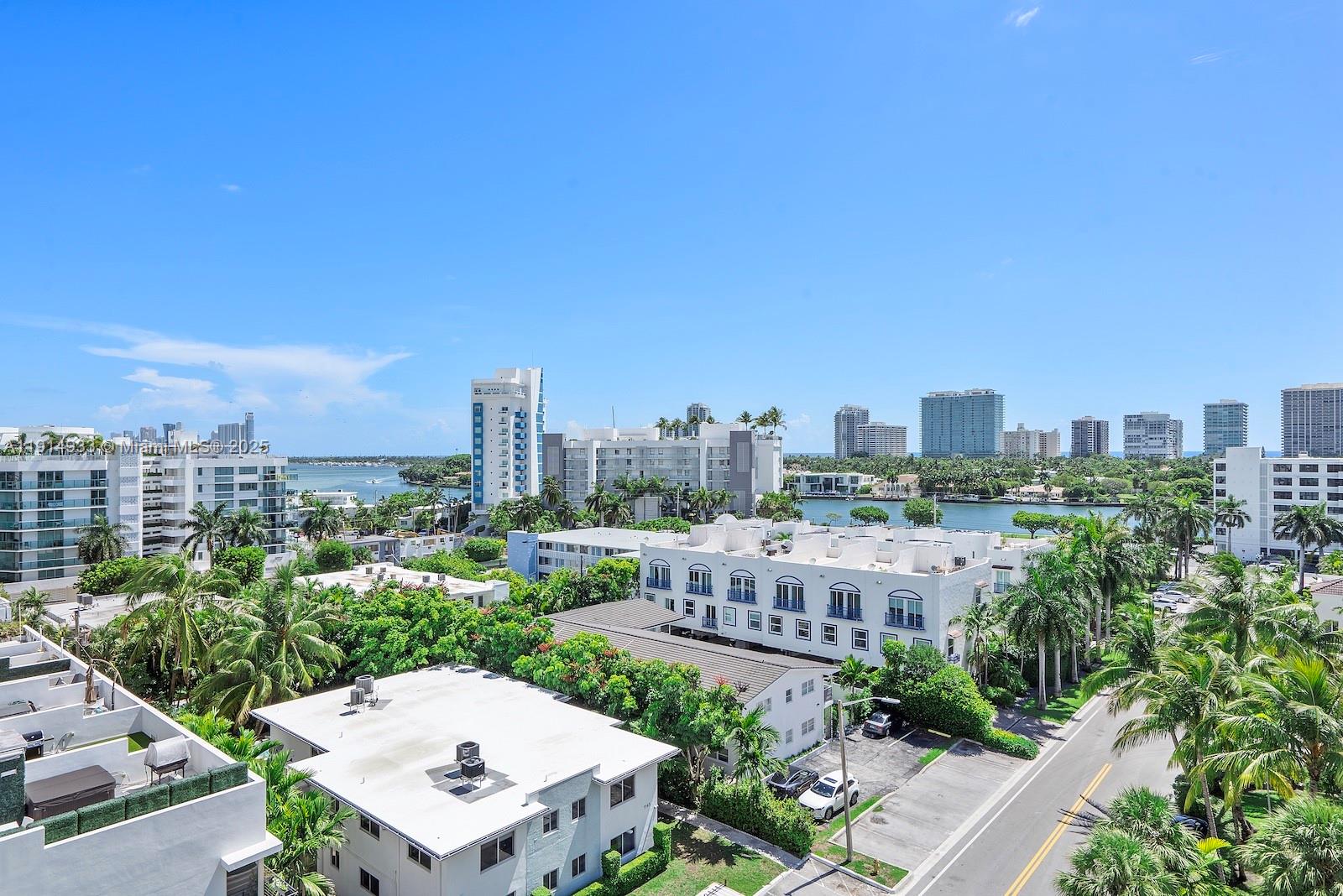 An elevated view shows a coastal neighborhood with apartment buildings, palm trees, and a waterway — 1150 101st St # 701, Bay Harbor Islands FL 33154, BAY HARBOR ISLANDS, FL