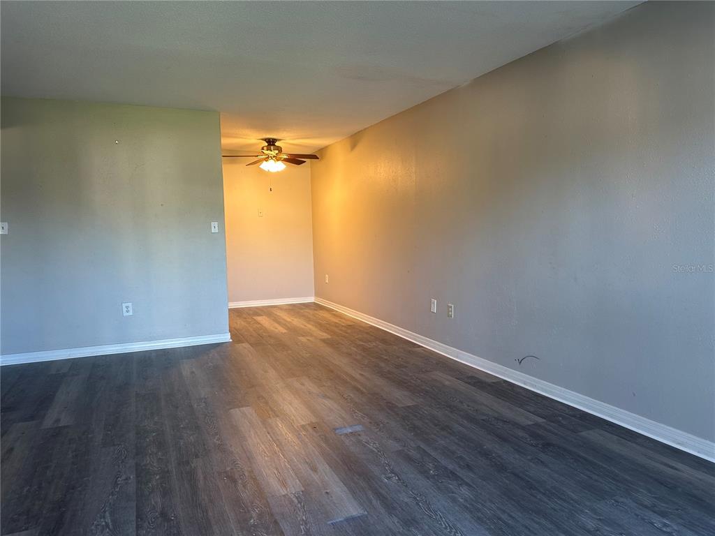 An empty room features gray walls, wood-look flooring, and a ceiling fan — 1695 LEE ROAD ROAD UNIT C110, WINTER PARK, FL