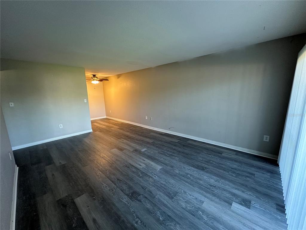 An empty room with gray walls and dark wood-look plank flooring — 1695 LEE ROAD ROAD UNIT C110, WINTER PARK, FL