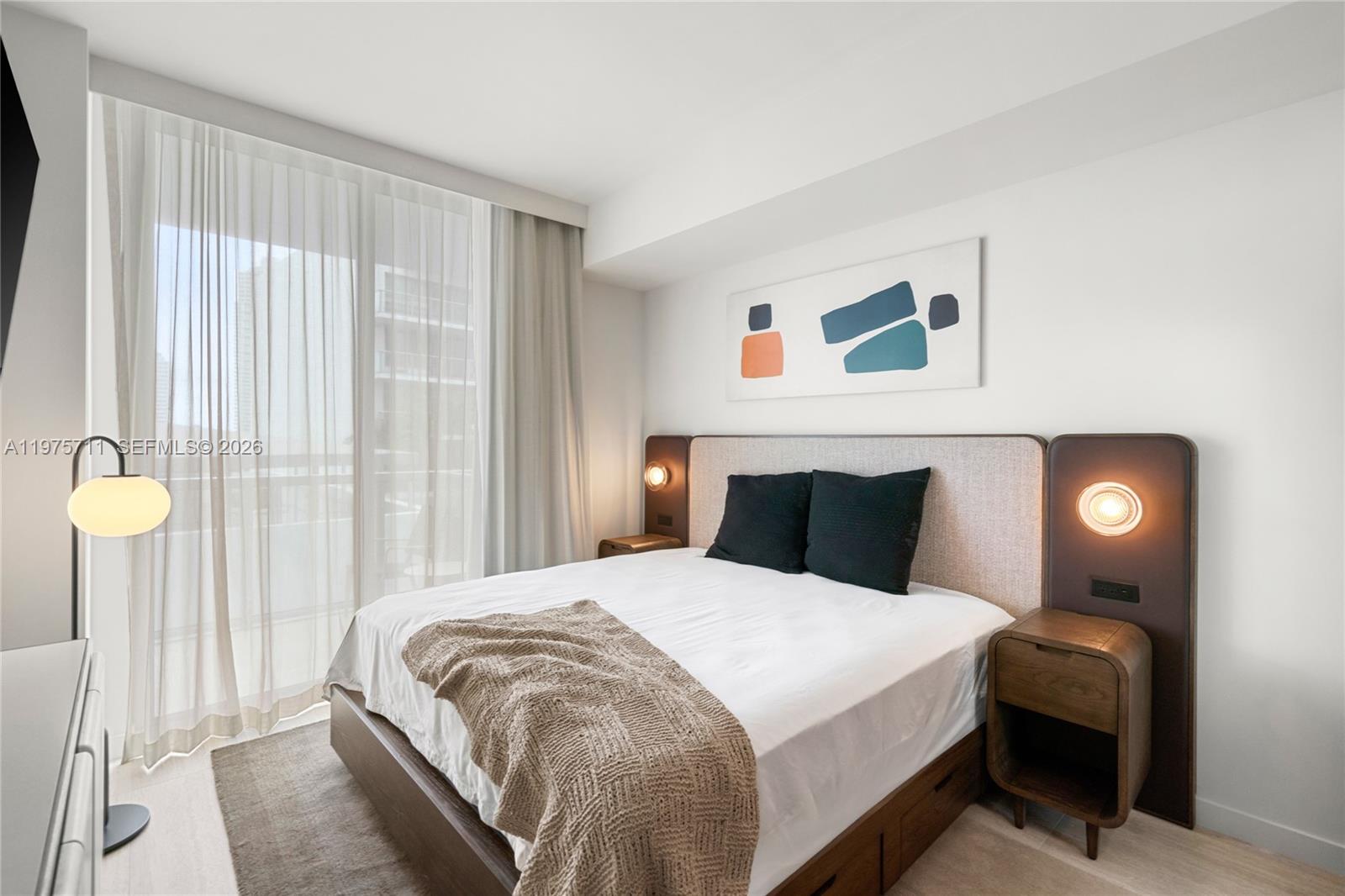 A modern bedroom features a queen bed, integrated nightstands, and floor-to-ceiling sheer curtains — 1611 SW 2nd Av # 504, Miami FL 33129, MIAMI, FL