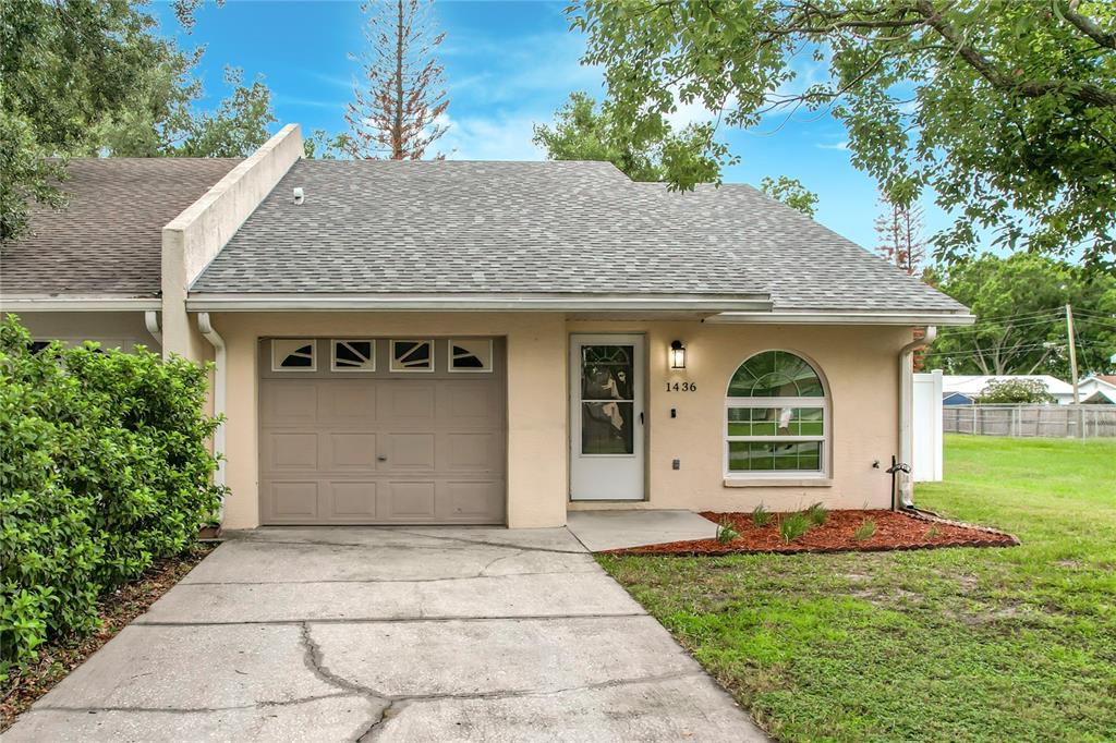 A single-story house with a beige stucco exterior, a garage, and a front-facing arched window — 1436 SHIRLEY DRIVE, LAKELAND, FL