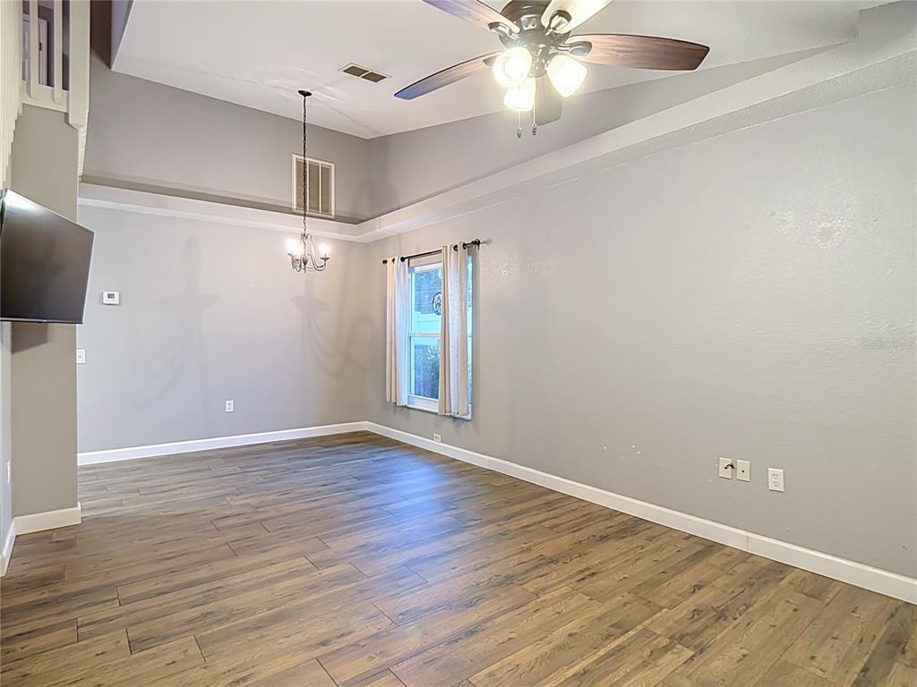A living room with light gray walls, wood-look tile flooring, and a vaulted ceiling — 1436 SHIRLEY DRIVE, LAKELAND, FL