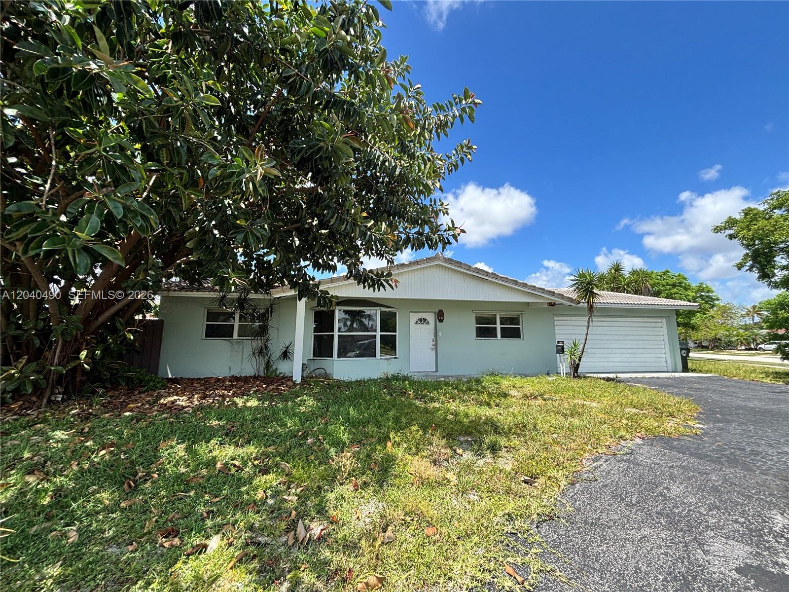 A single-story house with light green siding, a white front door, and an attached garage — 4300 NW 9th Ct, Coconut Creek FL 33066, COCONUT CREEK, FL