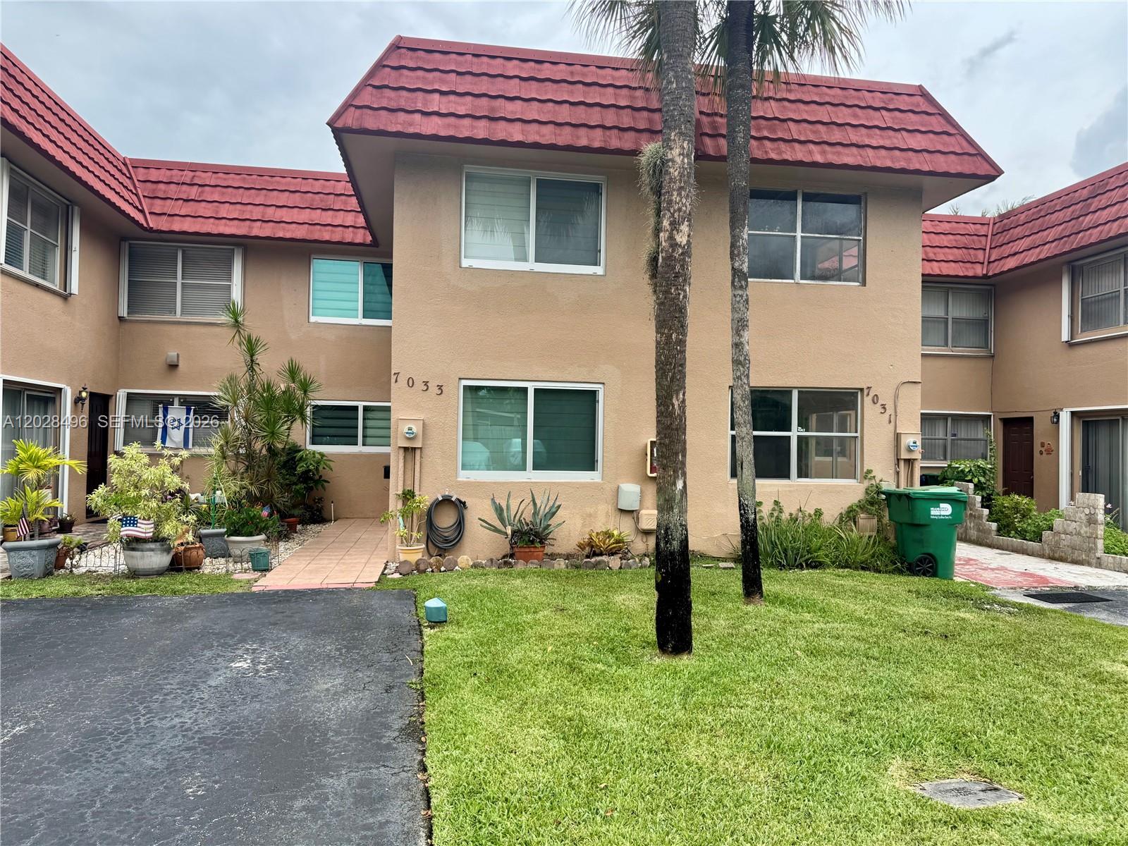 A kitchen features light wood cabinets, stainless steel appliances, and a patterned gray backsplash — 7033 NW 169th St, Hialeah FL 33015, HIALEAH, FL