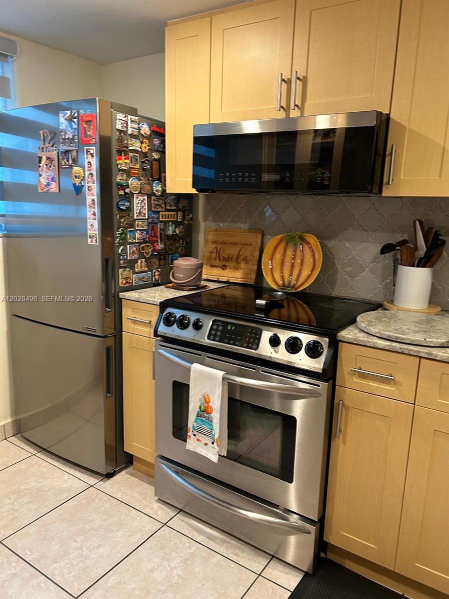 A bathroom features a gray vanity, a toilet, and a shower with a blue curtain — 7033 NW 169th St, Hialeah FL 33015, HIALEAH, FL