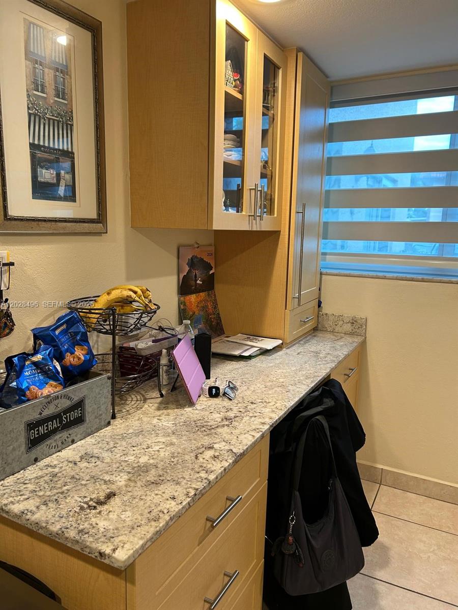 A small bathroom features a white toilet, a wooden vanity with a marble countertop, and a mirror — 7033 NW 169th St, Hialeah FL 33015, HIALEAH, FL