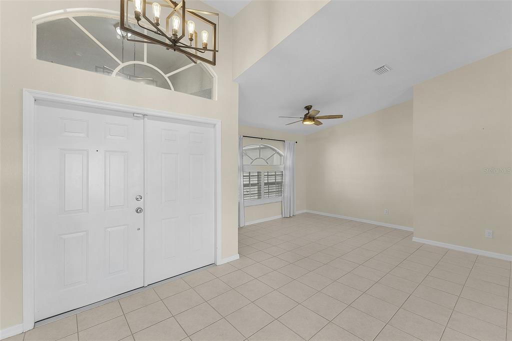 An entryway with tile flooring, a double front door, and a high vaulted ceiling — 1230 SW 4TH AVENUE, CAPE CORAL, FL