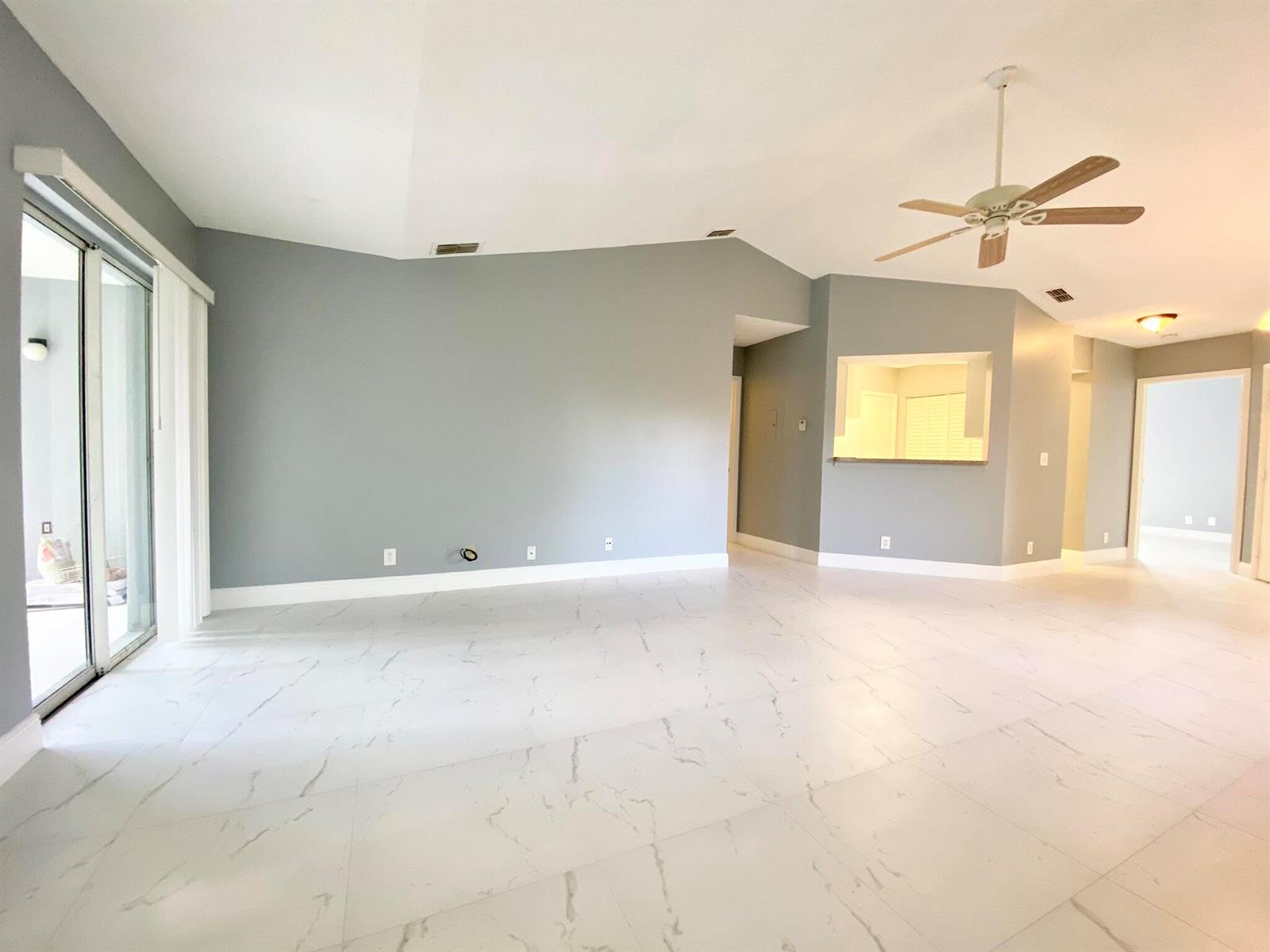 An empty living room features gray walls, white marble-look tile flooring, and a ceiling fan — 815 W Boynton Beach Boulevard # 201, Boynton Beach FL 33426, BOYNTON BEACH, FL
