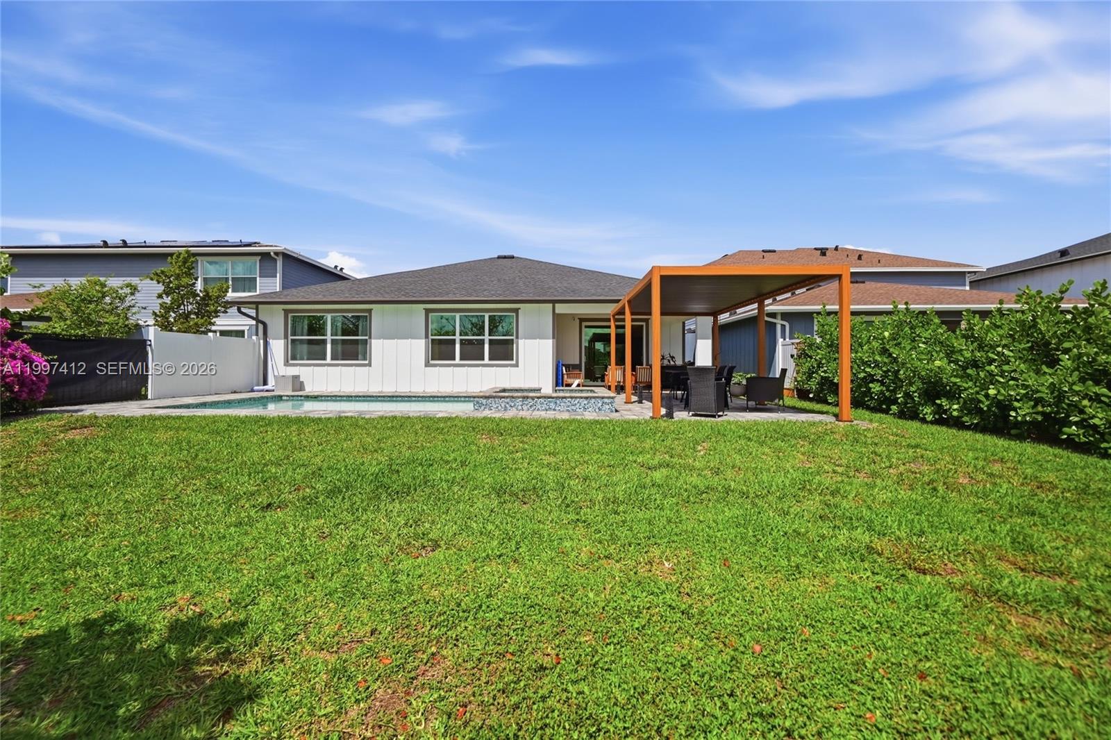 The backyard features a swimming pool, a patio with a pergola, and a grassy lawn — 1322 TIMBER REAP TRL, Loxahatchee FL 33470, LOXAHATCHEE, FL
