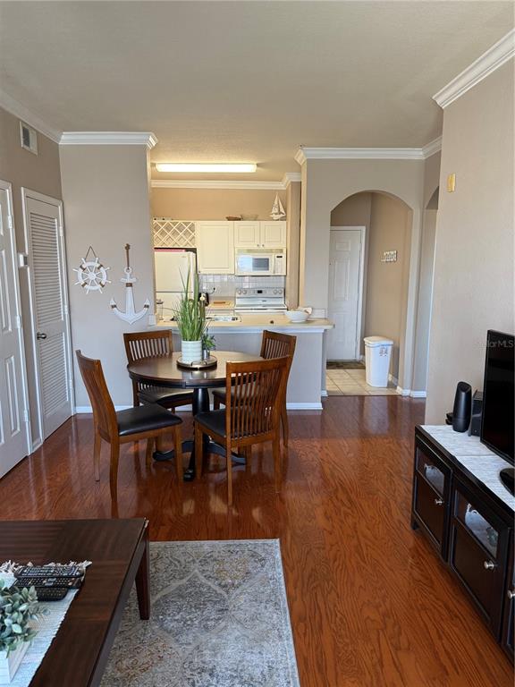 A dining area with a round table and chairs sits adjacent to a kitchen — 1216 S MISSOURI AVENUE UNIT 406, CLEARWATER, FL