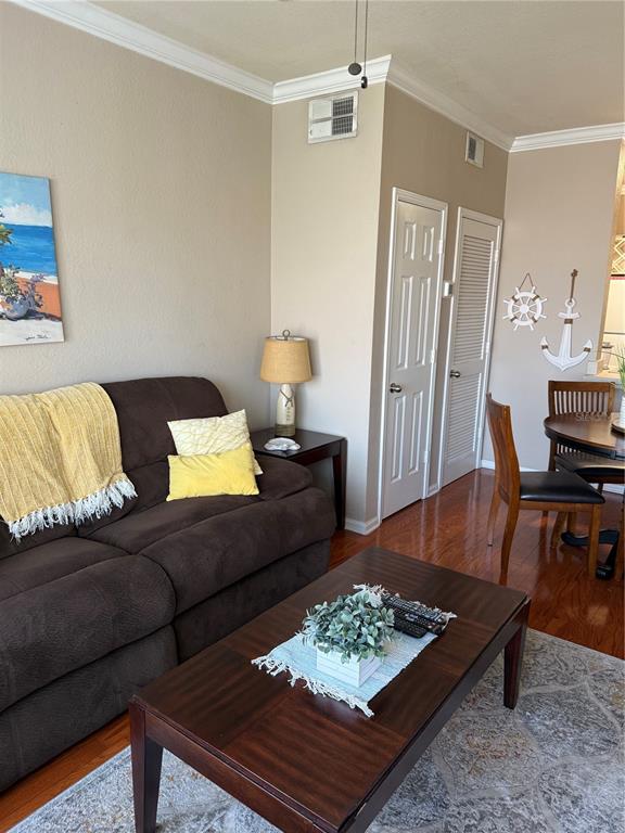 A living room features a brown sofa, a wooden coffee table, and nautical wall decor — 1216 S MISSOURI AVENUE UNIT 406, CLEARWATER, FL
