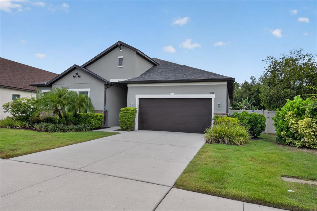 A gray single-story house with a two-car garage and a concrete driveway — 735 116TH COURT NE, BRADENTON, FL