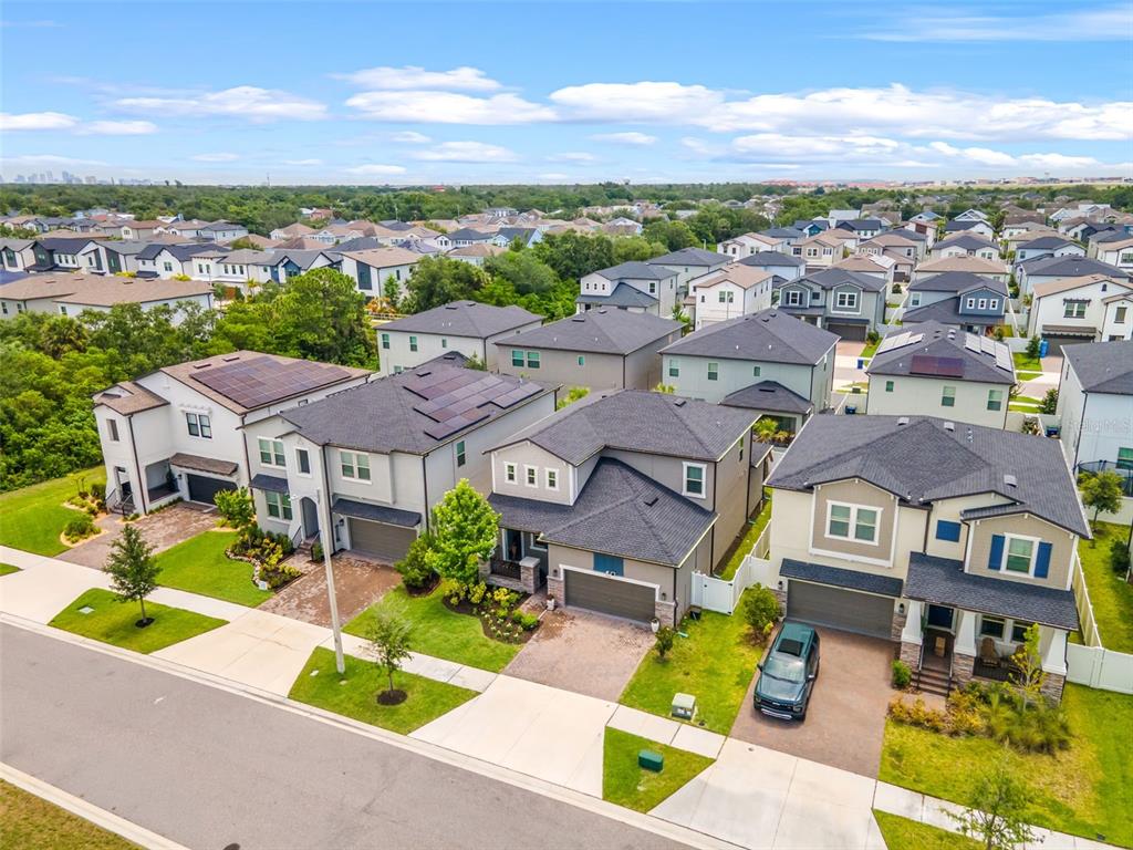 An aerial view shows a suburban neighborhood with several modern two-story houses and paved driveways — 7706 S JUANITA STREET, TAMPA, FL