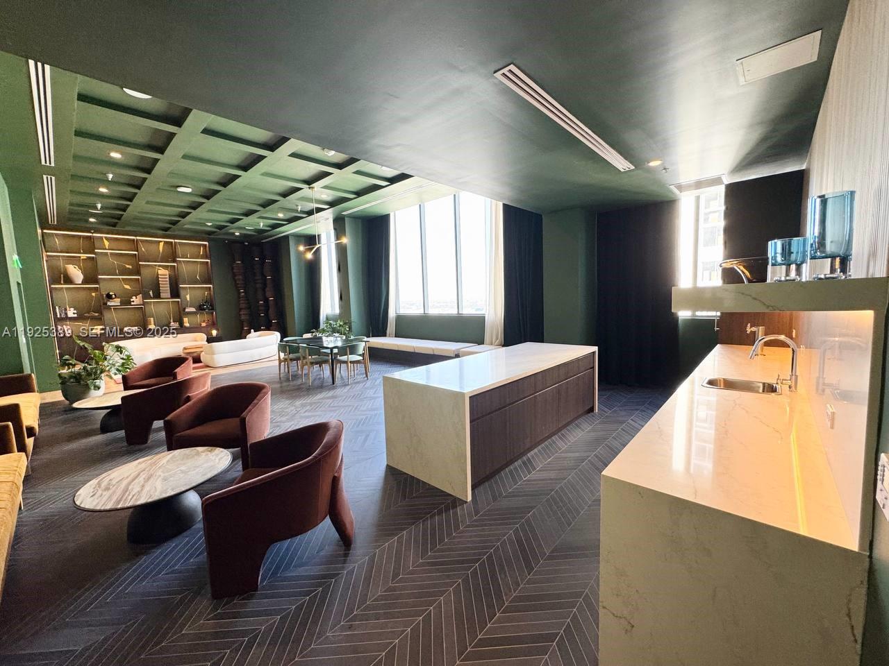 A modern lounge area features a coffered green ceiling, herringbone flooring, and a kitchenette — 11 NE 6th # 2813, Miami FL 33132, MIAMI, FL