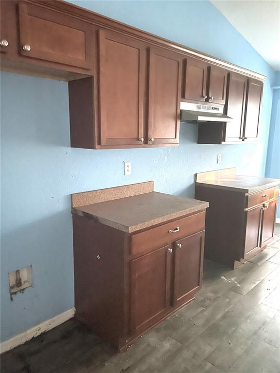 A kitchen features brown wooden cabinets, laminate countertops, and light blue walls — 2 REDWOOD TRACK RUN, OCALA, FL