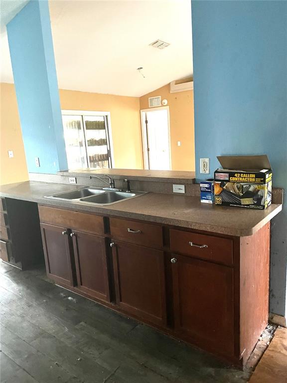 A kitchen features a double-basin sink, brown wooden cabinets, and a laminate countertop — 2 REDWOOD TRACK RUN, OCALA, FL