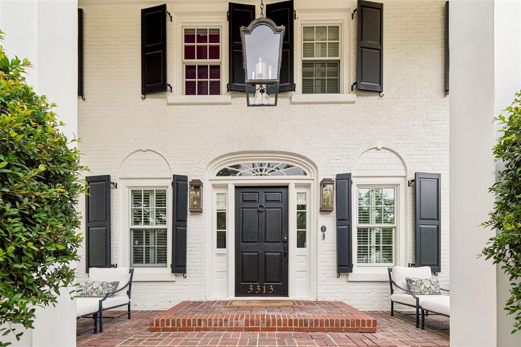 A white brick house exterior features a black front door, shutters, and a brick porch — 3313 W MULLEN AVENUE, TAMPA, FL