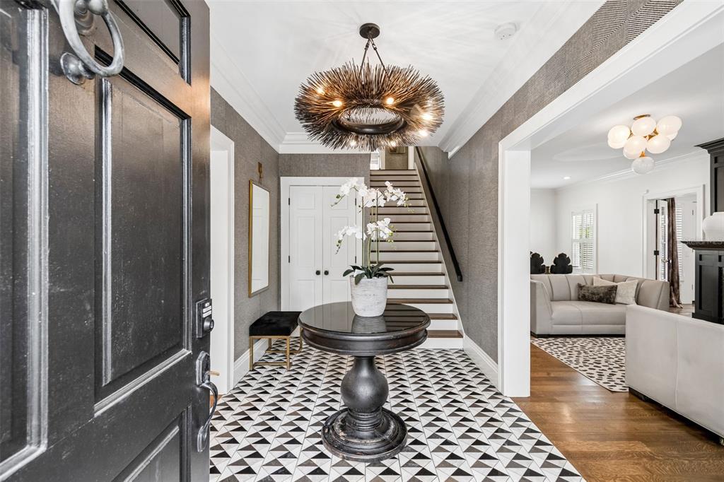 A foyer features a black and white patterned floor, a pedestal table, and a chandelier — 3313 W MULLEN AVENUE, TAMPA, FL