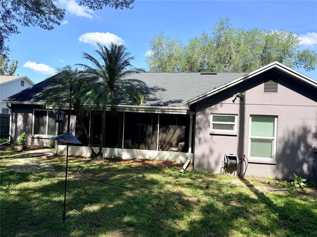 The exterior of a gray house features a screened-in porch and a palm tree — 1808 POWDER RIDGE DRIVE, VALRICO, FL