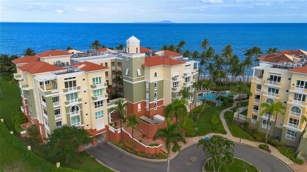 An aerial view of a multi-story resort complex with palm trees and the ocean nearby — 500 OCEAN DRIVE UNIT 553, HUMACAO, PR