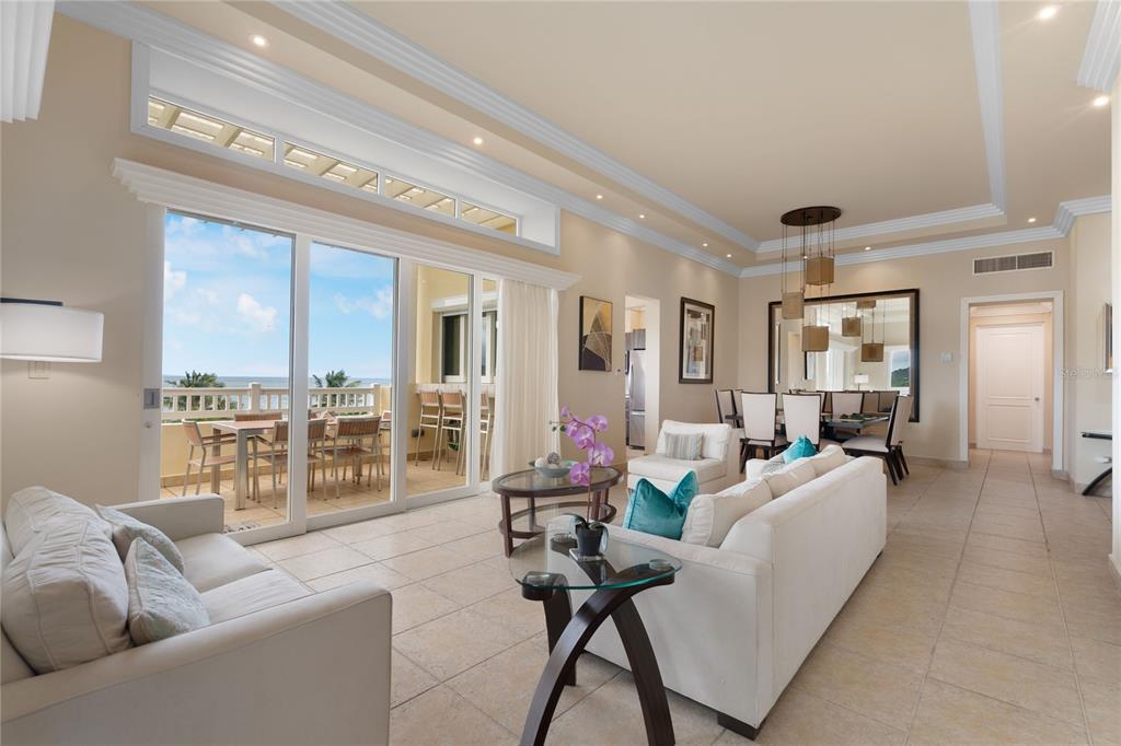 A bright living and dining area features tile floors, white sofas, and a balcony view — 500 OCEAN DRIVE UNIT 553, HUMACAO, PR