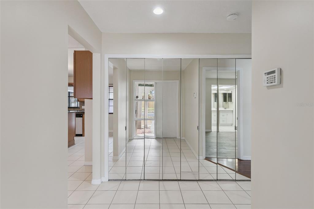 A tiled entryway features a wall of floor-to-ceiling mirrored closet doors and recessed lighting — 6246 SILVER GLEN COURT, ORLANDO, FL