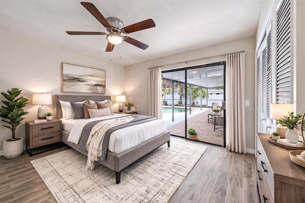 A bedroom with a bed, ceiling fan, and sliding glass doors opening to a pool patio — 6246 SILVER GLEN COURT, ORLANDO, FL