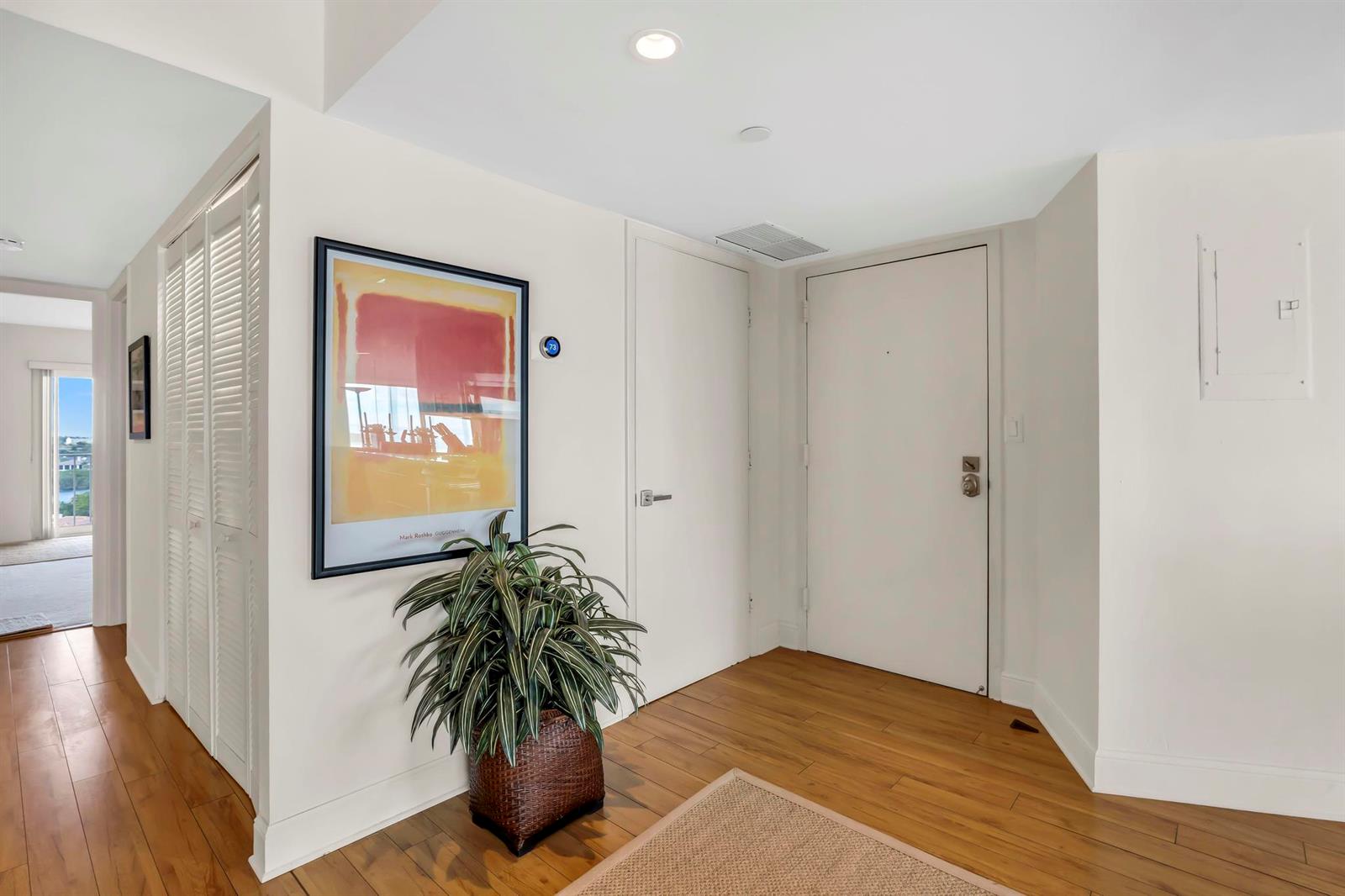 An entryway features wood flooring, a framed print, a potted plant, and a white door — 4301 N Ocean Boulevard # 1002, Boca Raton FL 33431, BOCA RATON, FL