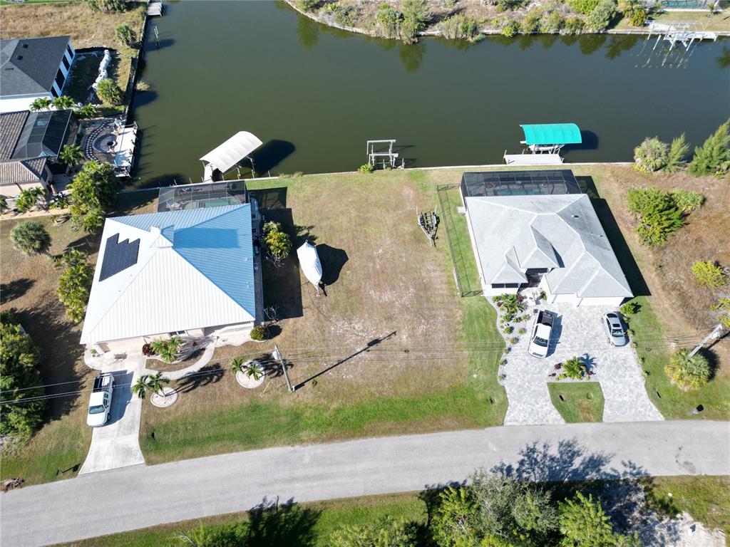 An aerial view shows two waterfront houses with boat docks and a vacant lot between them — 8050 ARLEWOOD CIRCLE, PORT CHARLOTTE, FL