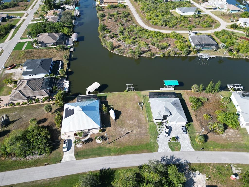 An aerial view shows two waterfront houses with boat docks along a canal — 8050 ARLEWOOD CIRCLE, PORT CHARLOTTE, FL