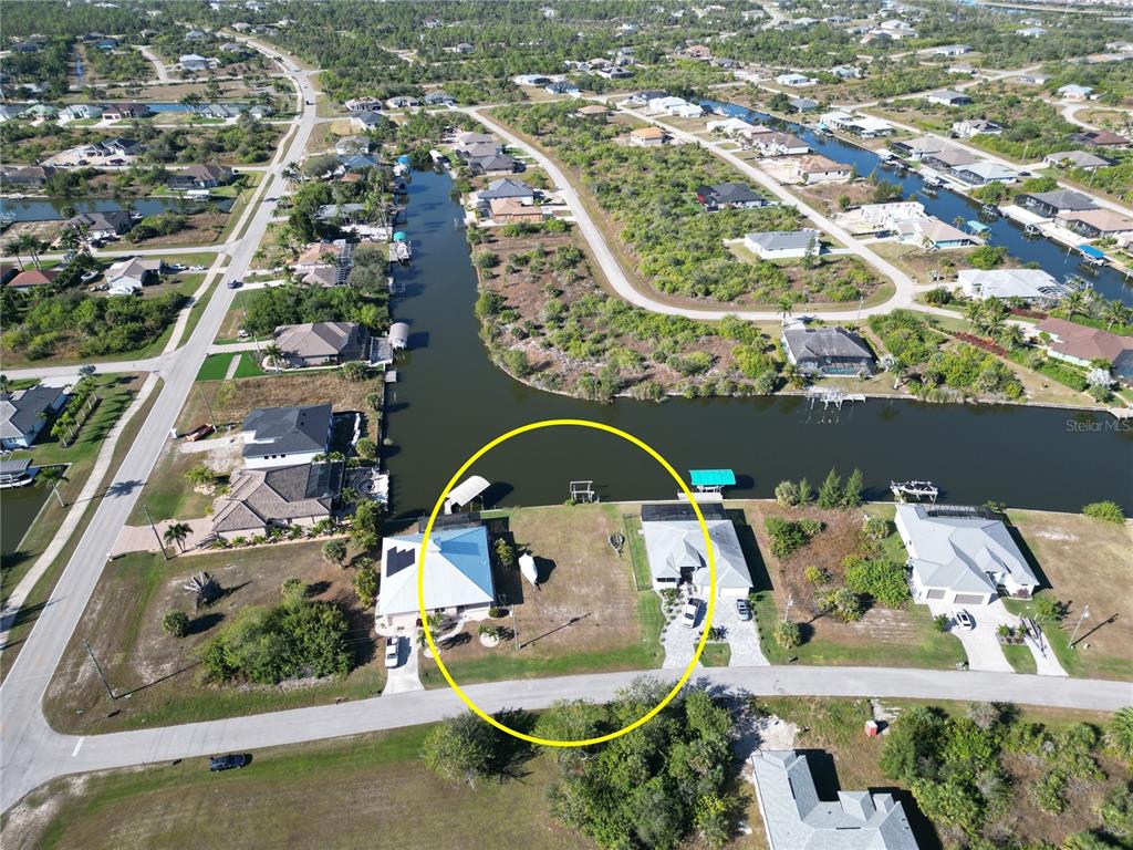 An aerial view shows two waterfront houses with a vacant lot between them — 8050 ARLEWOOD CIRCLE, PORT CHARLOTTE, FL