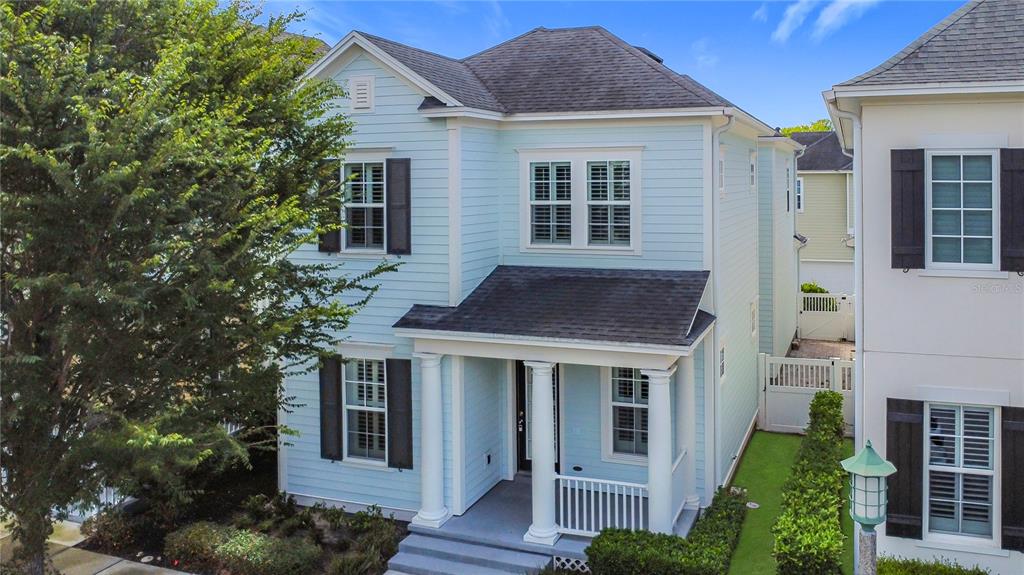 A light blue two-story house with white columns, dark shutters, and a front porch — 1513 RESOLUTE STREET, CELEBRATION, FL