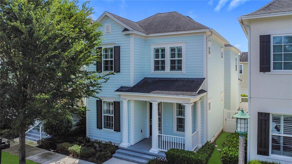 A light blue two-story house with a front porch and white columns — 1513 RESOLUTE STREET, CELEBRATION, FL