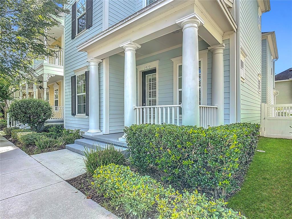 A light blue house features a front porch with white columns and a small yard — 1513 RESOLUTE STREET, CELEBRATION, FL