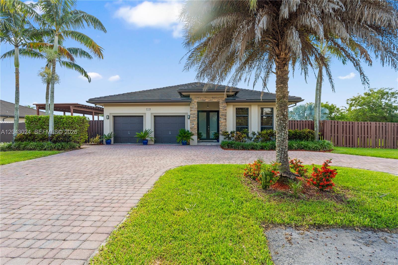 A single-story house with a two-car garage, stone accents, and a paved driveway — 21365 SW 177th Ct, Miami FL 33187, MIAMI, FL