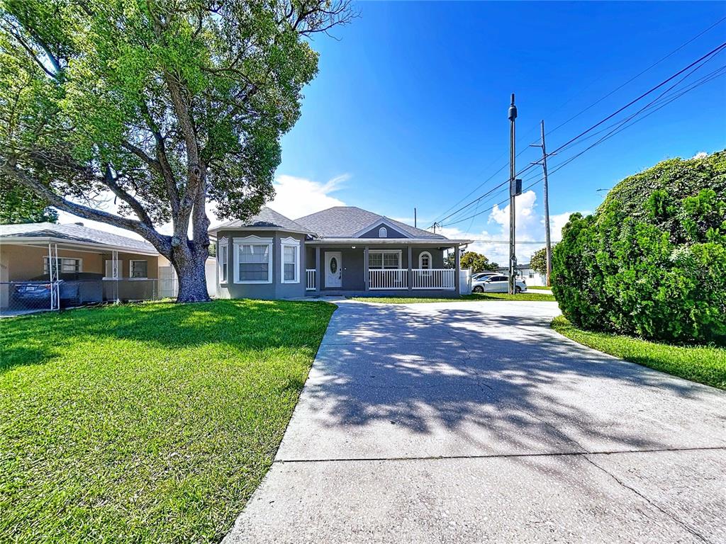 A gray single-story house with a white porch and a large tree in the yard — 3324 W ABDELLA STREET, TAMPA, FL
