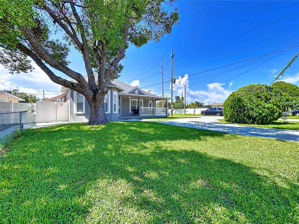 A single-story house with a large tree in the front yard and a covered porch — 3324 W ABDELLA STREET, TAMPA, FL