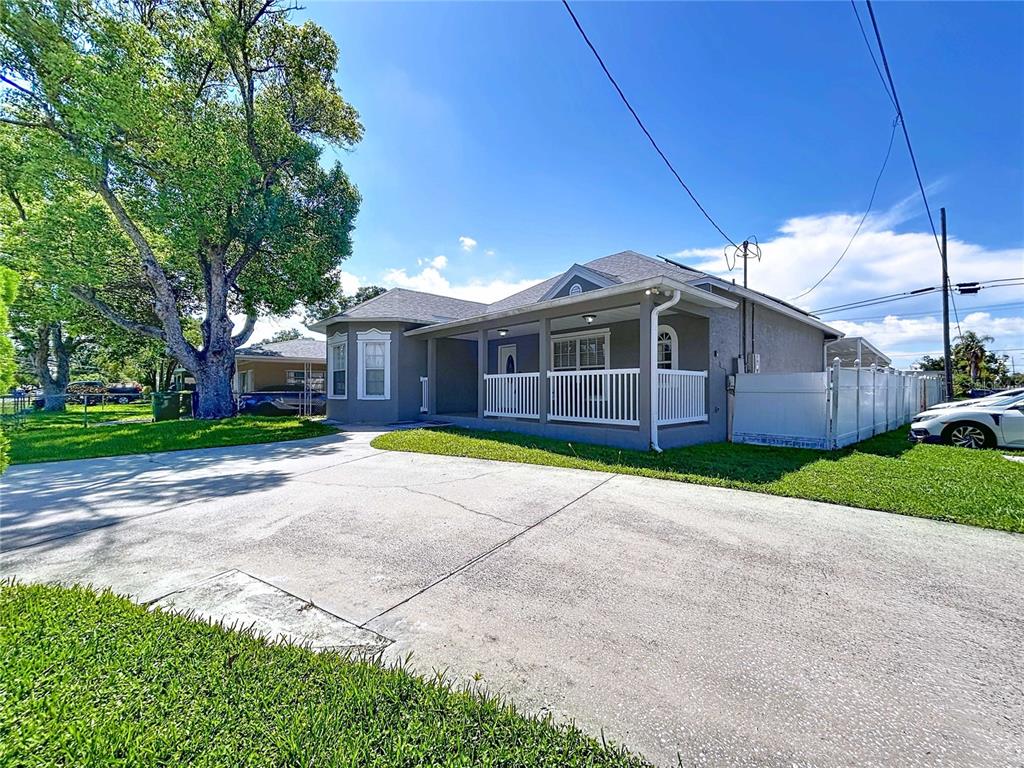 A single-story house with a covered front porch, white railings, and a concrete driveway — 3324 W ABDELLA STREET, TAMPA, FL