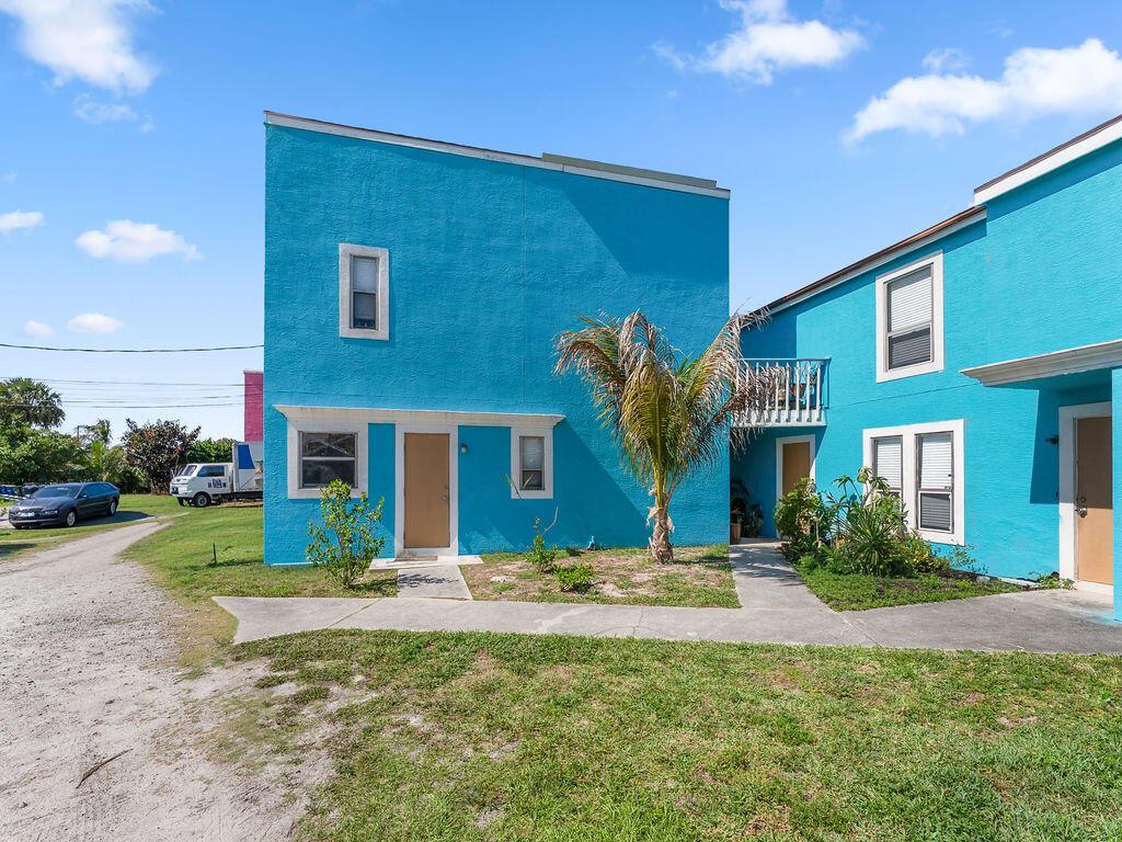 A bright blue two-story building with a palm tree and a concrete walkway in front — 642 Eldorado Street, Fort Pierce FL 34949, FORT PIERCE, FL
